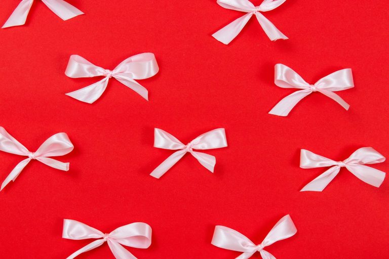 White satin ribbon bows arranged on a red background