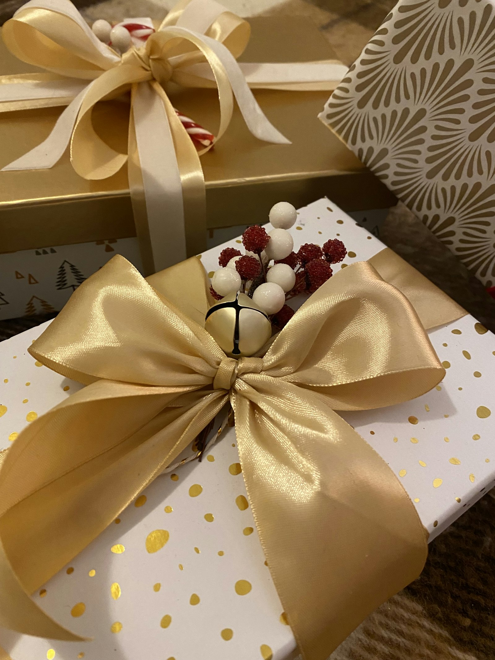 Christmas gift boxes decorated with wide gold and cream ribbon bows